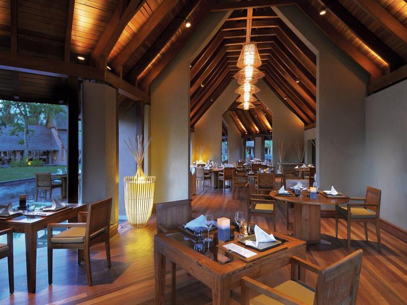 Elegantní restaurace s dřevěnými podlahami, dřevěnými stoly a teplým osvětlením v atmosféře chaty.