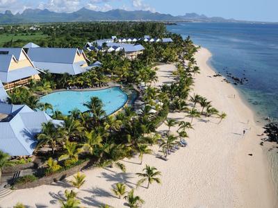 Uitzicht op een tropisch resort met zwembad, palmbomen en zandstrand aan de blauwe zee.