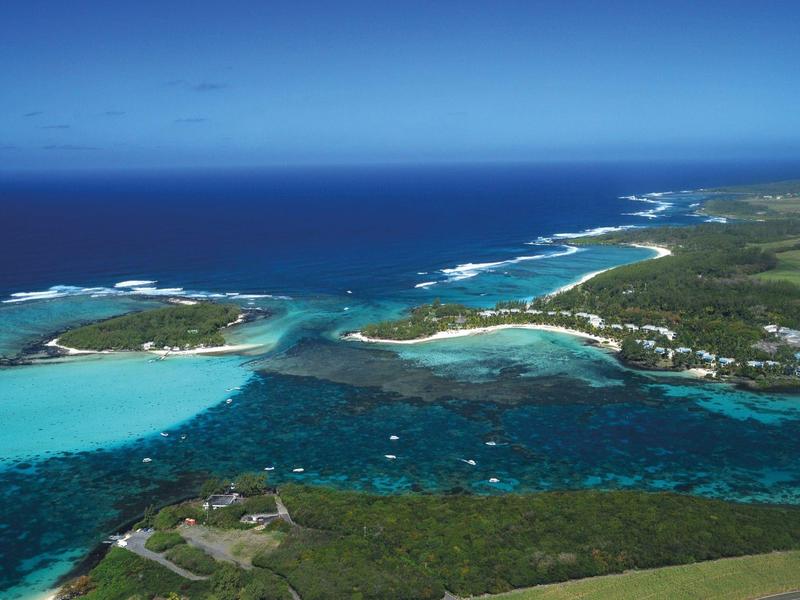 Türkisblaues Meer umgibt grüne Inseln mit Sandstränden unter klarem blauen Himmel.