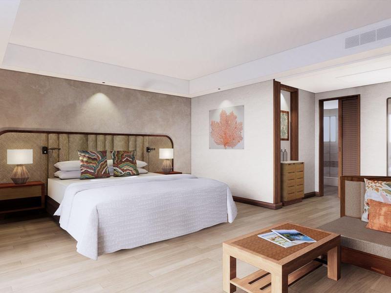 Modernes Schlafzimmer mit großem Bett, Holz- und beigen Möbeln, Sofa und hellem Holzboden.