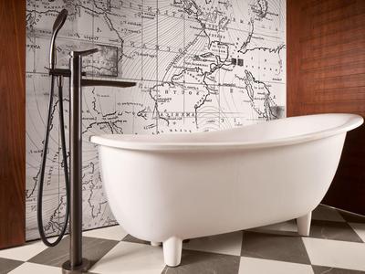 Elegante freistehende Badewanne vor einer Weltkarte, umgeben von Holz- und Fliesenwänden.