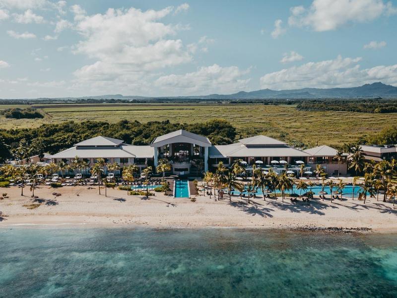 Strandresort met parasols en ligstoelen aan helder zee en uitgestrekt kustlandschap