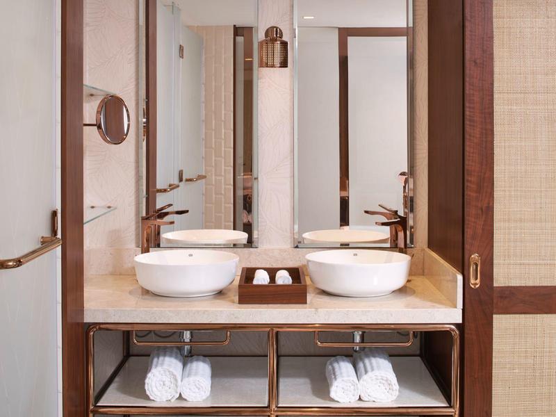 Moderne badkamer met dubbele wastafels en grote spiegels in warme houttinten.