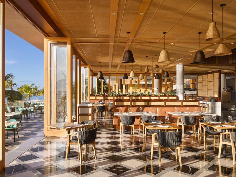 Modern restaurant met houten accenten, zwart-witte tegels en uitzicht op het terras.