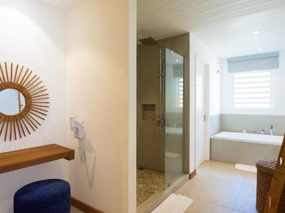 Moderne badkamerruimte met bad, inloopdouche en decoratieve spiegel.