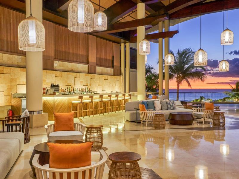 Luxurious hotel lounge area with sea view at sunset.