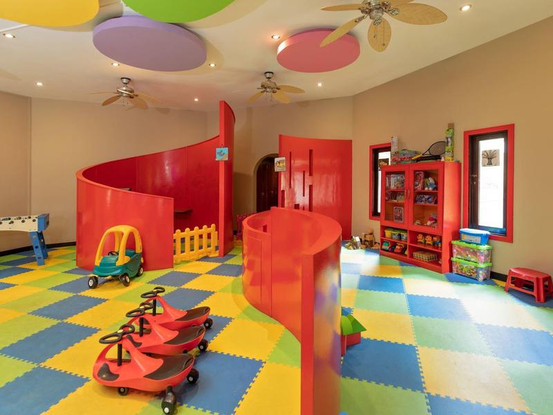 Colorful children's playroom with foam flooring, red climbing structure, and toys.
