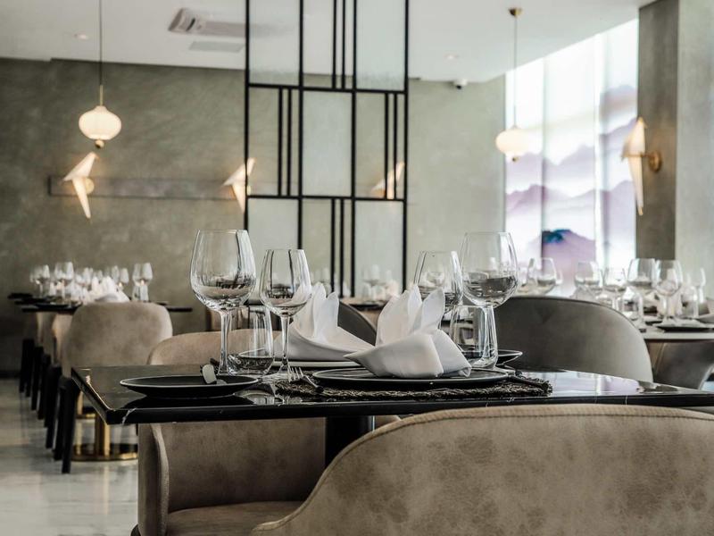 Elegant restaurant met stijlvolle tafels, wijnglazen en moderne verlichting.