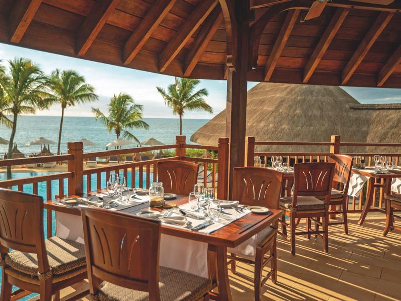 Openluchtrestaurant met houten meubels en zeezicht bij zonneschijn