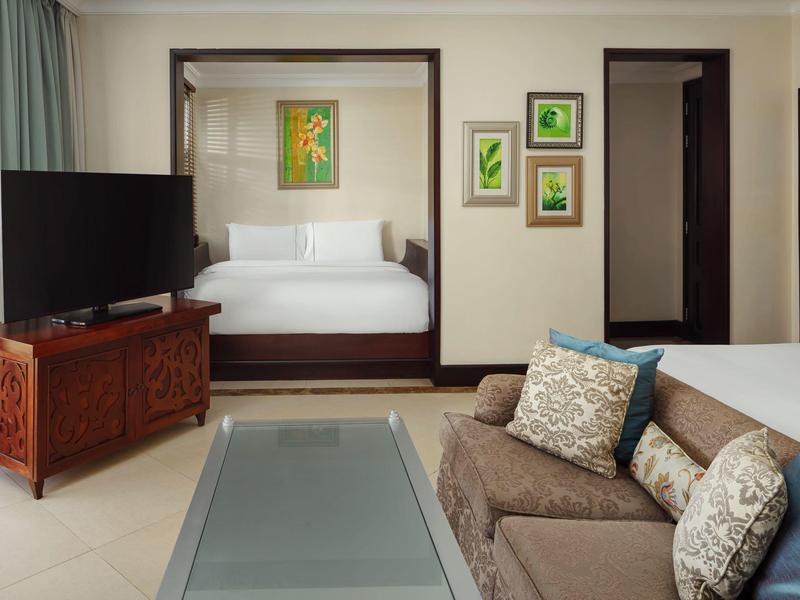 Moderne hotelkamer met een comfortabel bed, bank en flatscreen-tv.