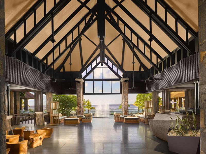 Ruime open lounge met houten balkenplafond en uitzicht op water