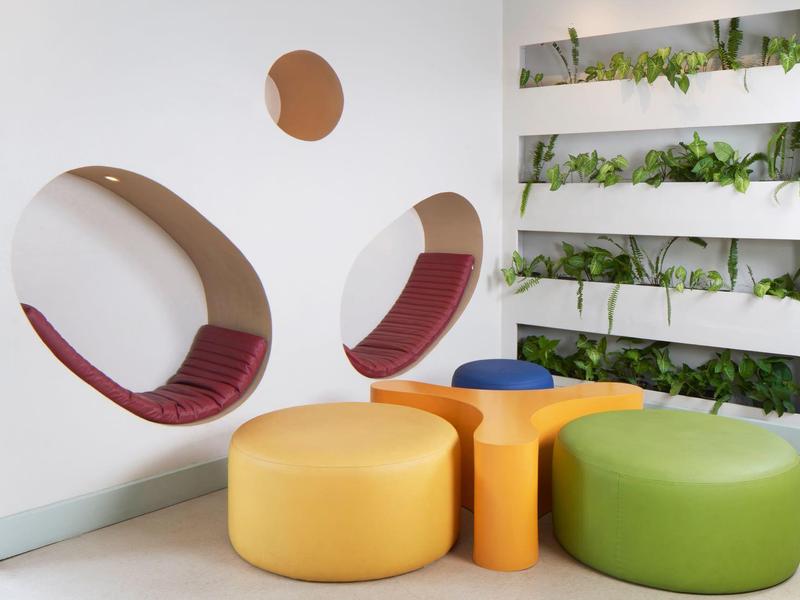 Moderne wachtruimte met kleurrijke zitplaatsen en ingebouwde nissen met kussens
