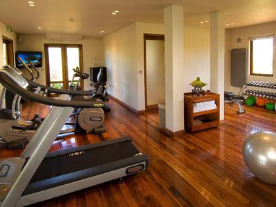 Fitnessraum mit Holzfußboden, Laufband, Trainingsgerät und Gymnastikball