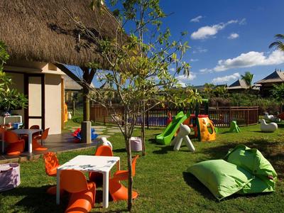 Kolorowy plac zabaw dla dzieci ze zjeżdżalniami i miejscami do siedzenia w hotelowym ogrodzie w słoneczny dzień.