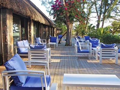 Terrazza con sedie blu e tavoli in un ambiente tranquillo e boscoso.