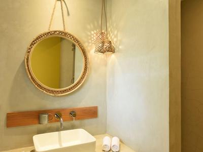 Modern bathroom with round mirror, sink, and minimal decoration.