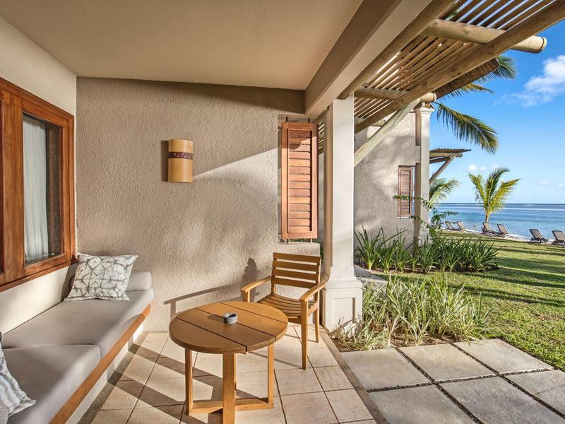Gemütliche Terrasse mit Holzmöbeln und Meerblick in einem Hotelresort.