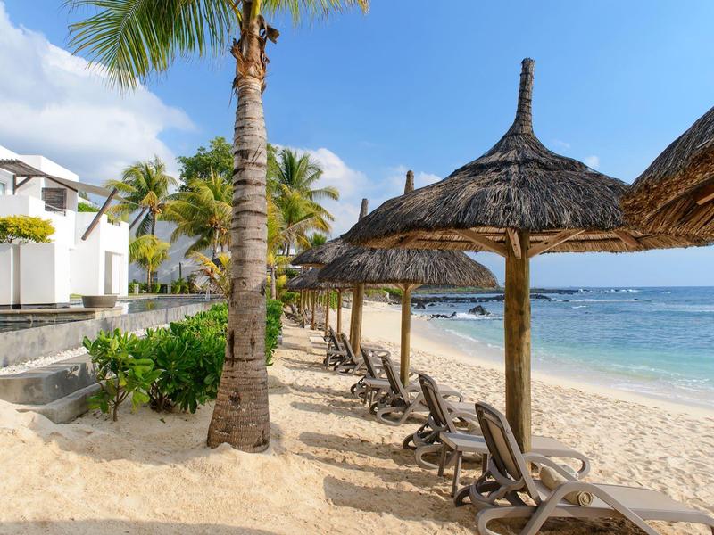 Spiaggia con lettini e ombrelloni di paglia in un hotel tranquillo sul mare.