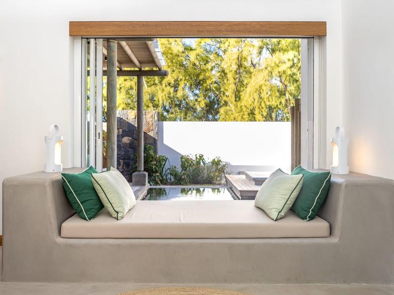 Modern windowsill sofa with green and white cushions in front of large window to terrace.