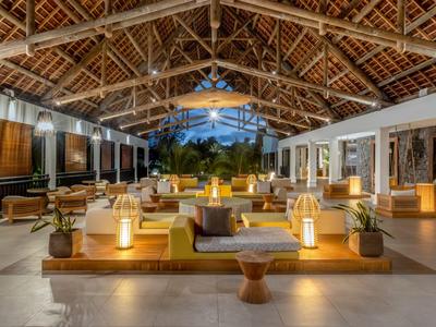 Offener, moderner Lobbybereich eines Resorts mit Holzdach und gemütlicher Beleuchtung