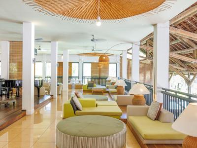 Helles, offenes Lounge-Bereich mit modernen Sitzmöbeln und großen Fenstern mit Blick ins Grüne.