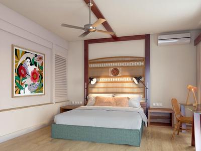 Moderní hotelový pokoj s velkou postelí, stropním ventilátorem, uměleckým dílem a přirozeným světlem z oken.