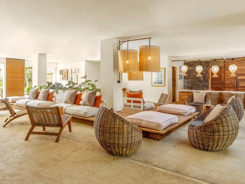 Světlá a moderní hotelová lobby s pohodlnými posezeními a dekoracemi v přírodních tónech.