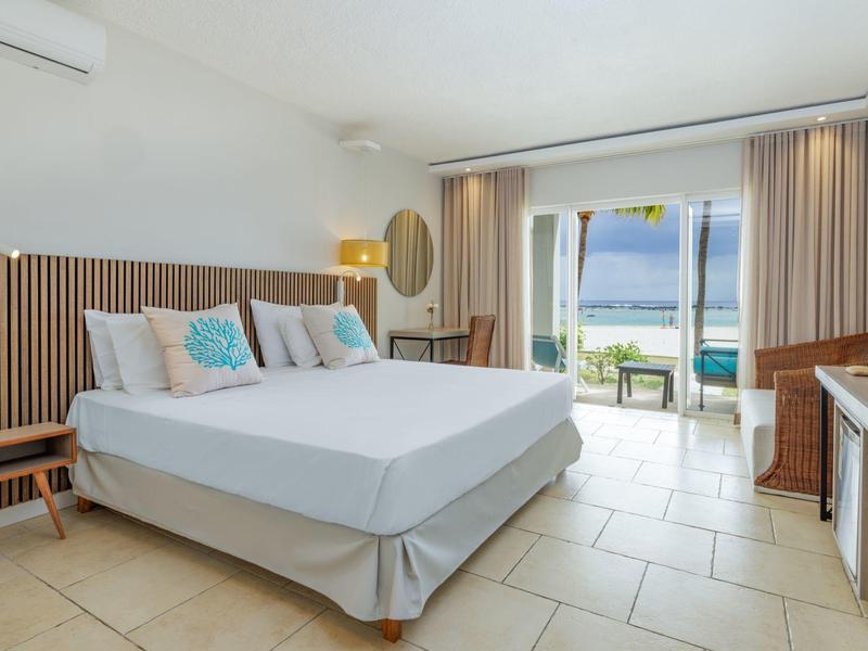 Moderní hotelový pokoj s manželskou postelí a balkonem s výhledem na moře