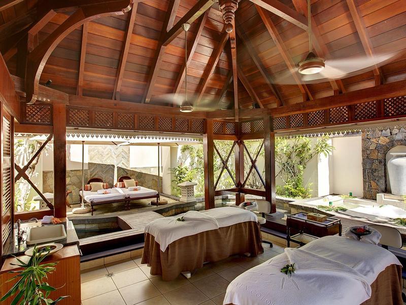 Offener Massagebereich mit Holzdach, zwei Liegen und entspannter, heller Atmosphäre.