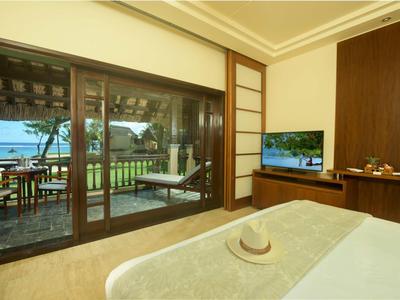 Hell eingerichtetes Schlafzimmer mit Terrasse, Ozeanblick und naturfarbenen Holzmöbeln.