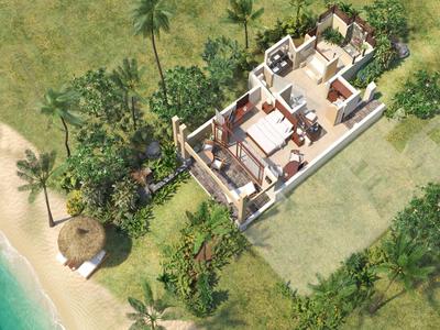 Vogelperspektive eines kleinen Hauses mit Garten an einem Strand mit Palmen und Sandstrand.