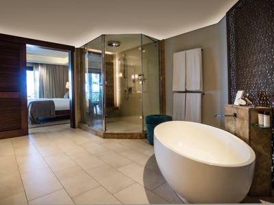 Baño moderno con ducha acristalada, bañera independiente y mobiliario oscuro