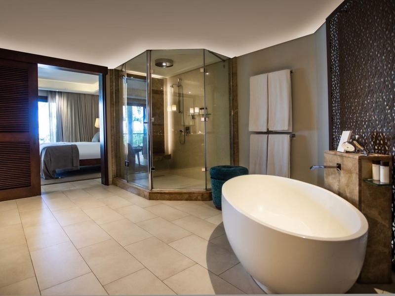 Baño moderno con ducha acristalada, bañera independiente y mobiliario oscuro