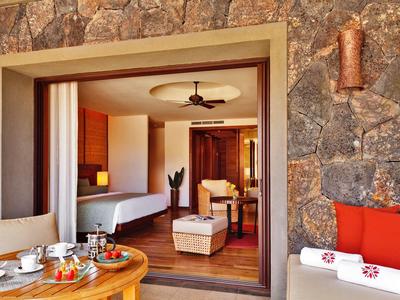 Příjemná hotelová terasa s výhledem na útulný pokoj a rustikální kamenné zdi.