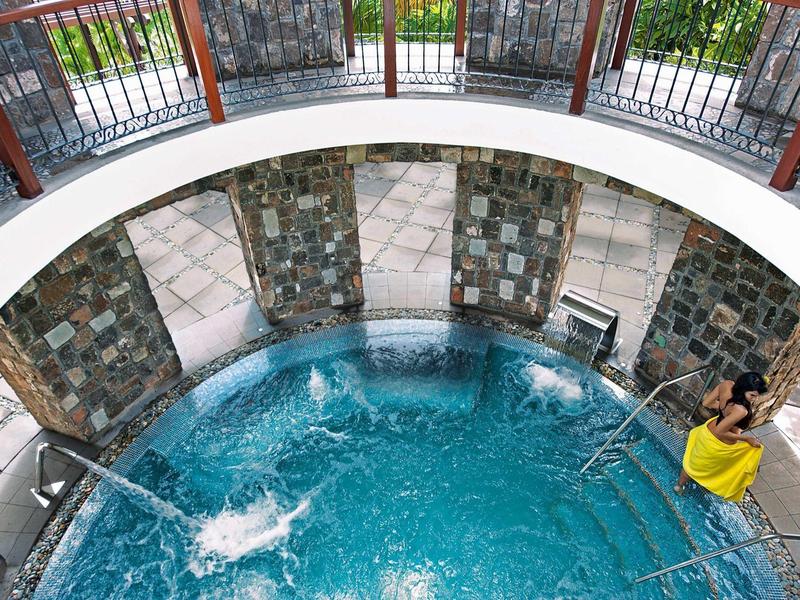 Kulaté venkovní vířivka s bublající vodou a posezením.