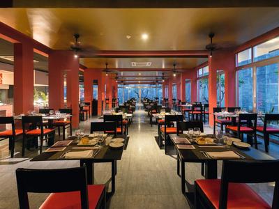 Modernes Restaurant mit Holzsäulen, schwarzen Stühlen und großen Fenstern