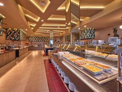 Großer Buffetbereich mit beleuchteten Decken und vielseitigem Speiseangebot im Hotelrestaurant.