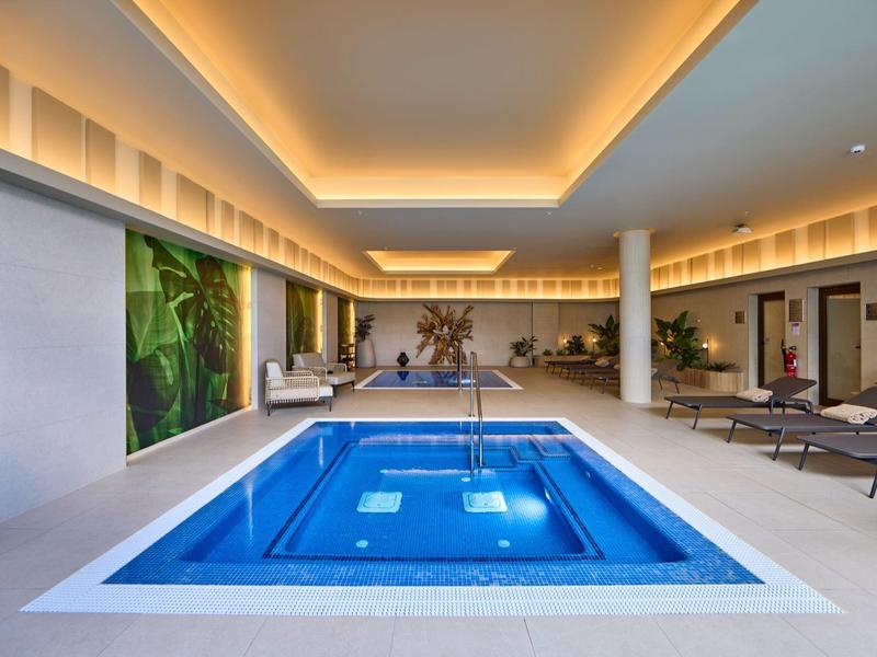 Modernes Hallenbad mit Whirlpool und entspannenden Liegebereichen