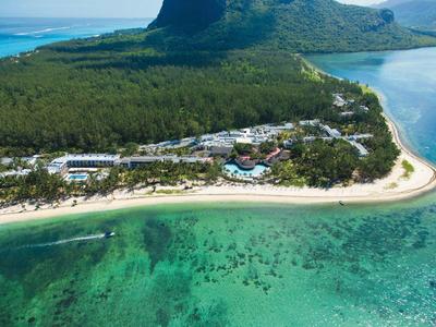 Luftaufnahme einer tropischen Insel mit weißem Sandstrand, klarem türkisfarbenem Wasser und Resortanlagen.