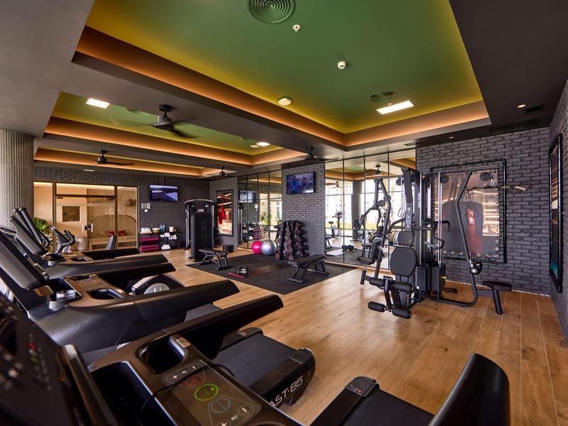 Moderner Fitnessraum mit Cardio- und Kraftgeräten in tollem Hotelambiente