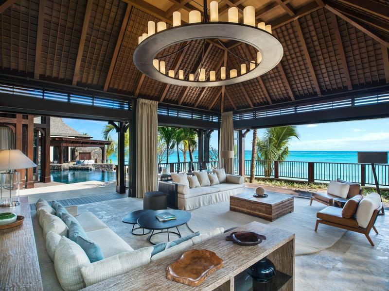 Spacious living area with open sea view, modern furniture, and wooden roof