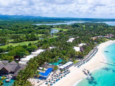 Aerial view of a tropical resort with beach, sun loungers, and turquoise sea.