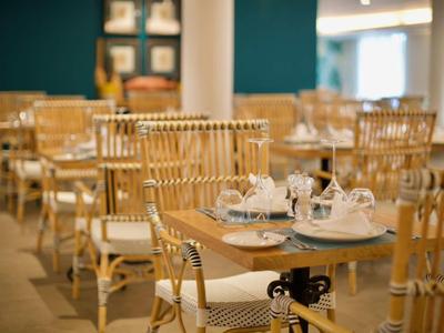 Accogliente area ristorazione dell'hotel con tavoli in legno e sedie in legno chiaro.