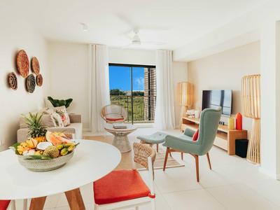 Soggiorno luminoso con mobili moderni e grandi finestre con vista.