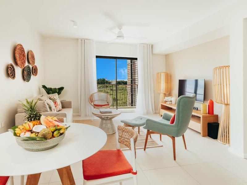 Soggiorno luminoso con mobili moderni e grandi finestre con vista.