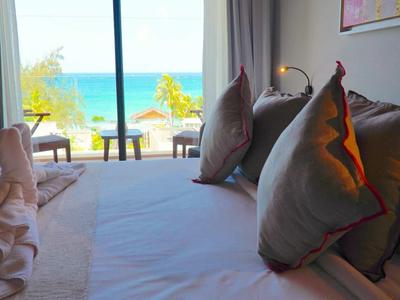 Pohodlný hotelový pokoj s výhledem na moře a umělecky složeným ručníkem.