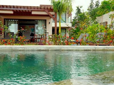 Blick auf einen Pool mit einem Haus und Garten im Hintergrund