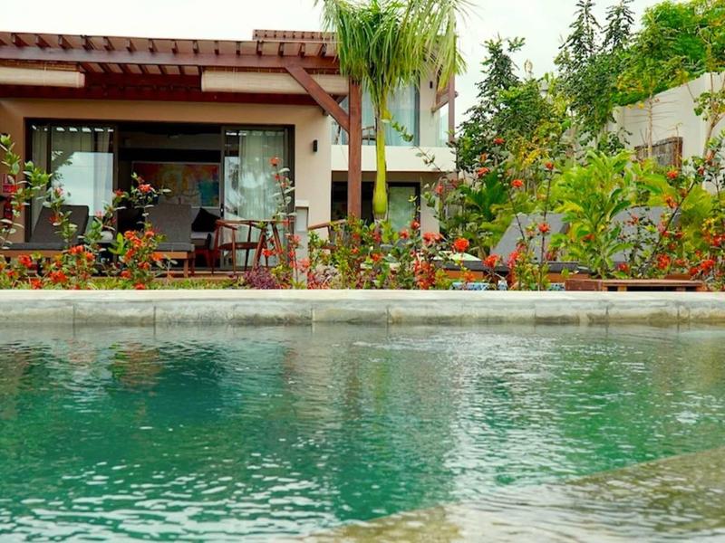 Bazén před malým rekreačním domem s terasou a zahradou.