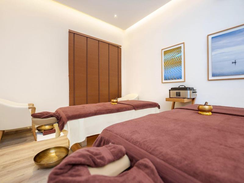 Pohodlná wellness místnost se dvěma masážními lehátky a teplým osvětlením.