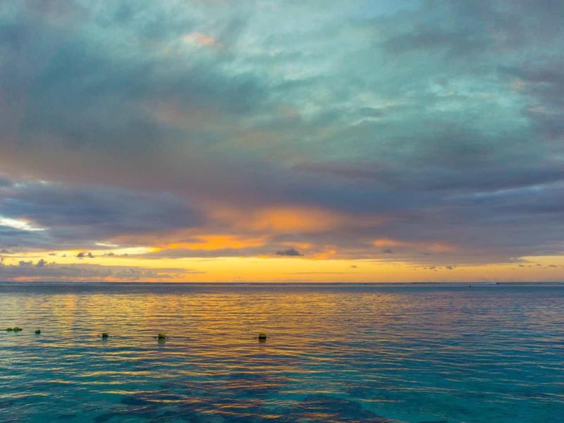 Dramatická obloha nad klidným mořem během barevného západu slunce.